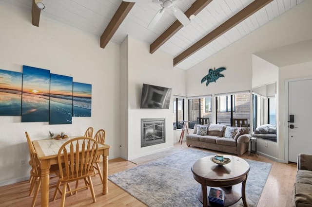 living room featuring wood ceiling, light hardwood / wood-style flooring, ceiling fan, beam ceiling, and high vaulted ceiling