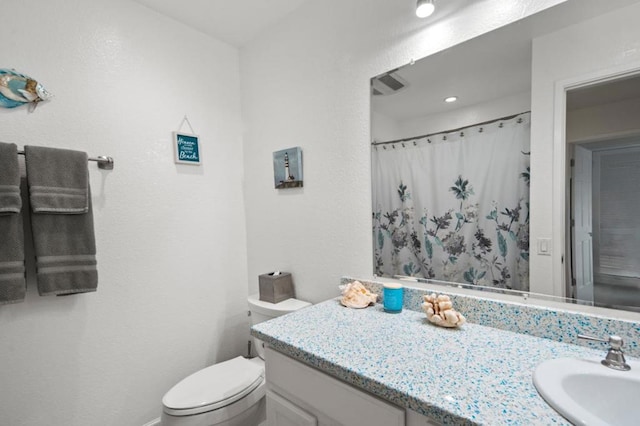 bathroom with vanity, toilet, and curtained shower