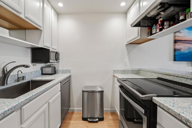 kitchen featuring white cabinetry, stainless steel appliances, sink, and light hardwood / wood-style flooring