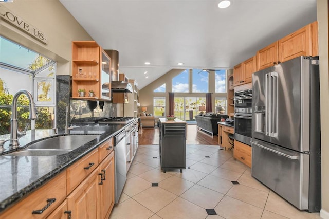 kitchen featuring tasteful backsplash, extractor fan, sink, stainless steel appliances, and dark stone counters