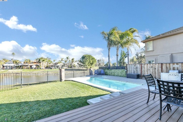 view of swimming pool featuring a patio area, a yard, and a water view