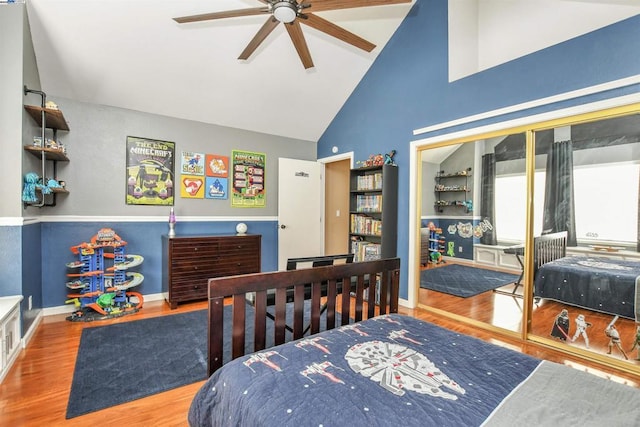 bedroom featuring ceiling fan, wood-type flooring, and high vaulted ceiling