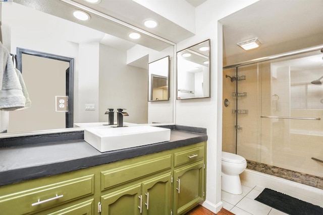 bathroom with toilet, vanity, an enclosed shower, and tile patterned floors