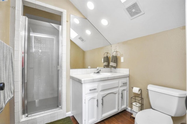 bathroom featuring toilet, lofted ceiling, walk in shower, and vanity