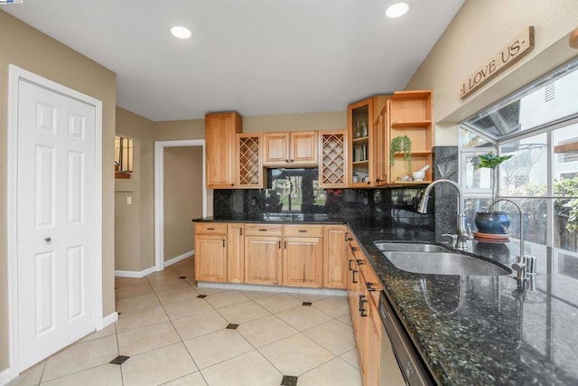 kitchen with dishwasher, decorative backsplash, sink, light tile patterned flooring, and dark stone counters