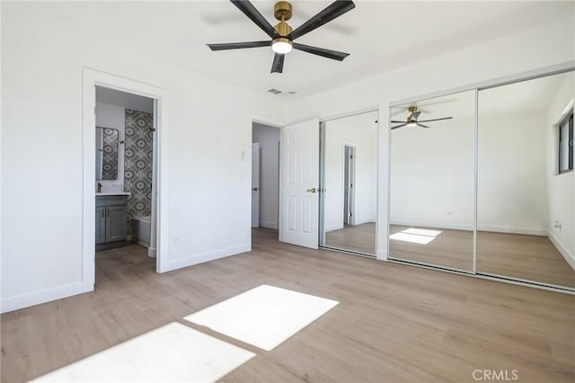 unfurnished bedroom featuring light wood-type flooring, ceiling fan, and ensuite bathroom