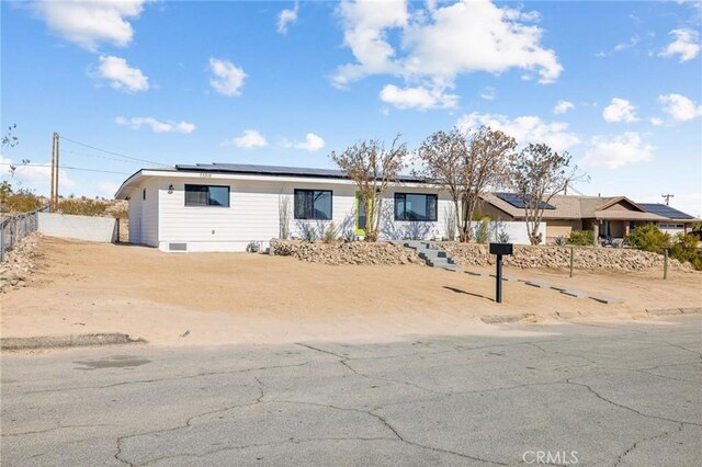 ranch-style home with solar panels