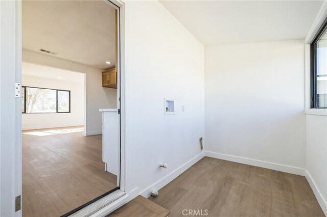 laundry room featuring washer hookup and light hardwood / wood-style floors