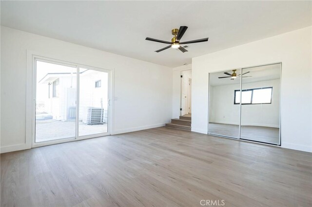 unfurnished bedroom with ceiling fan, access to exterior, hardwood / wood-style floors, and a closet