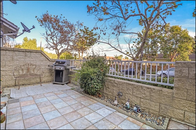 patio terrace at dusk featuring area for grilling