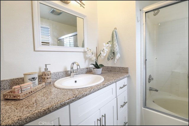 bathroom with vanity and combined bath / shower with glass door