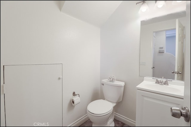 bathroom with vanity, toilet, and vaulted ceiling