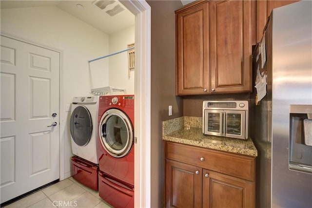 clothes washing area with washer and dryer and light tile patterned floors