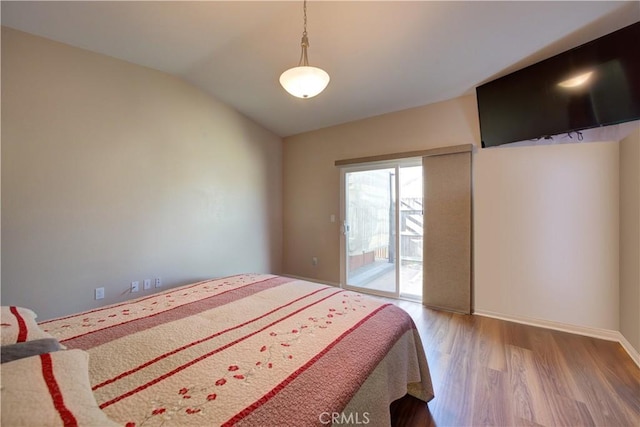 bedroom with vaulted ceiling, access to exterior, and hardwood / wood-style floors