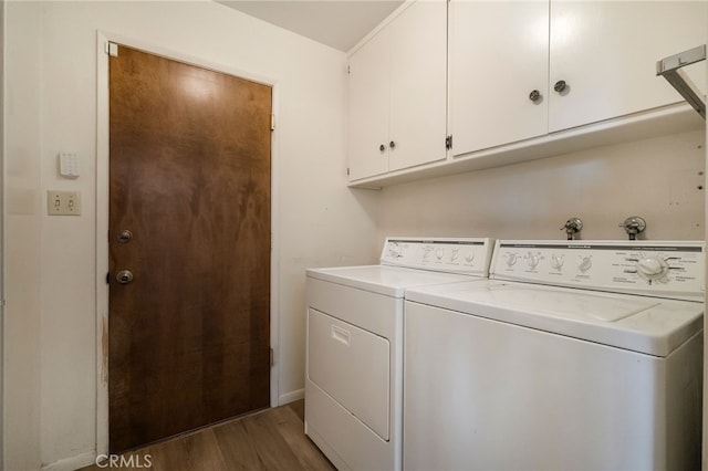 laundry area with cabinets, dark wood-type flooring, and washer and dryer