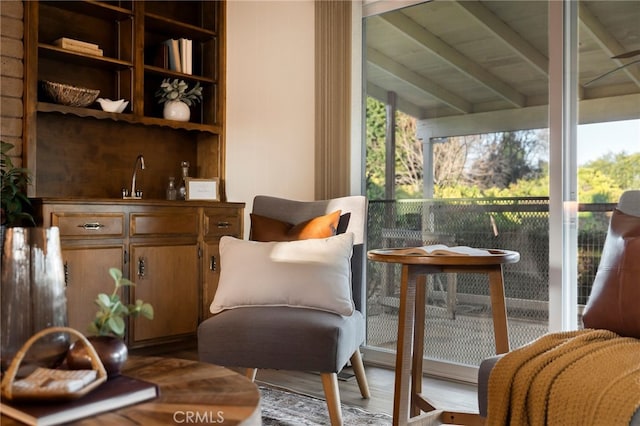 sitting room with hardwood / wood-style flooring and beamed ceiling