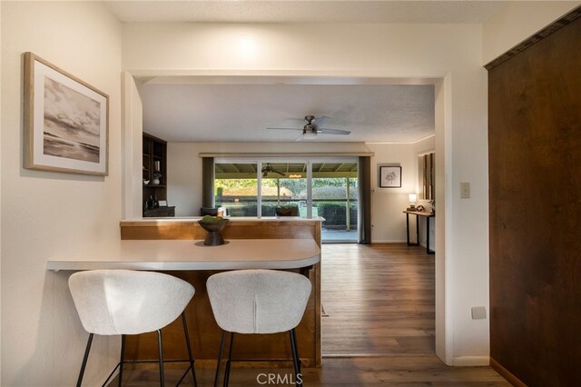 dining area featuring ceiling fan and dark wood-type flooring