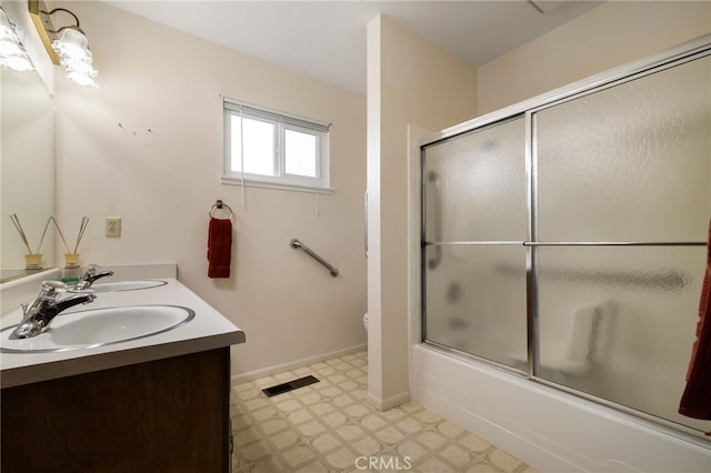 full bathroom featuring toilet, vanity, and shower / bath combination with glass door