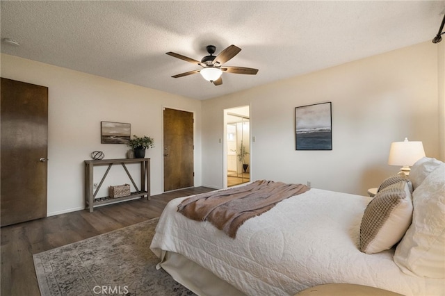 bedroom featuring a textured ceiling, ceiling fan, dark hardwood / wood-style flooring, and ensuite bath