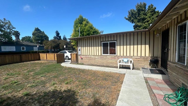 view of property exterior with a patio and a yard