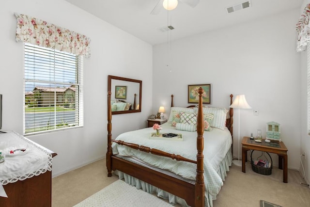 carpeted bedroom with ceiling fan and multiple windows