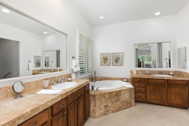 bathroom featuring tiled tub and vanity