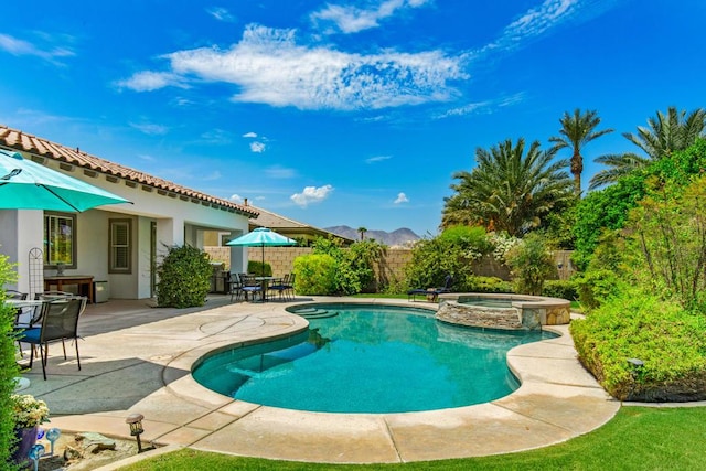 view of swimming pool featuring an in ground hot tub, a mountain view, and a patio