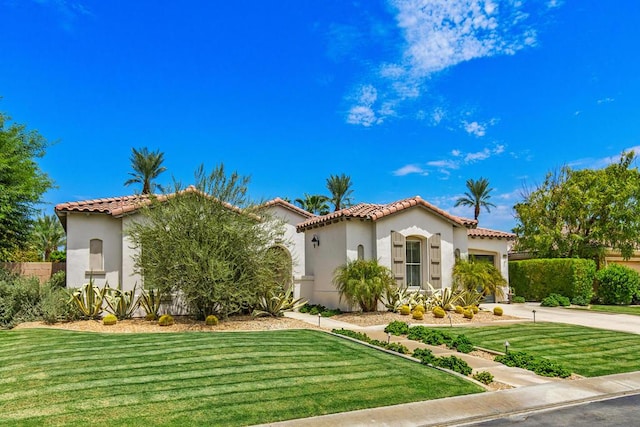 mediterranean / spanish-style home with a front lawn and a garage