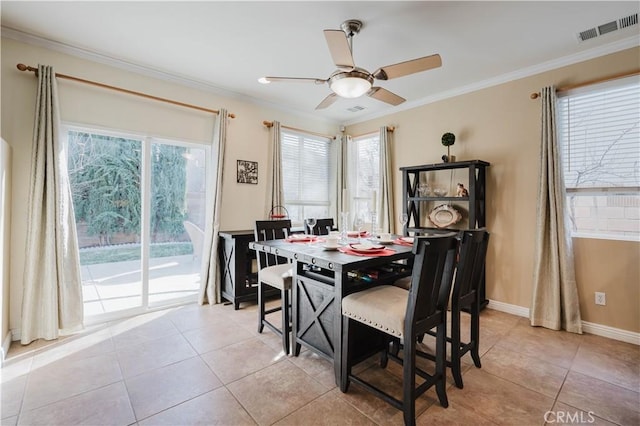 dining space with light tile patterned floors, ceiling fan, a wealth of natural light, and crown molding