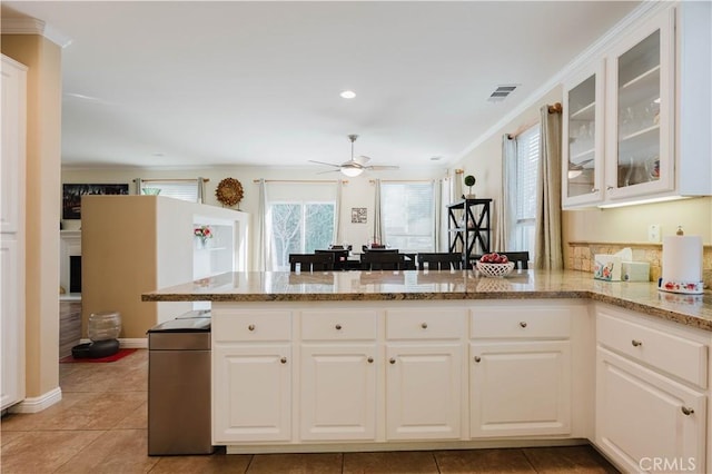 kitchen with white cabinetry, kitchen peninsula, and light stone counters