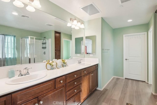 bathroom featuring an enclosed shower, hardwood / wood-style floors, and vanity