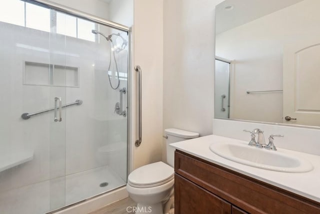 bathroom featuring hardwood / wood-style flooring, walk in shower, vanity, and toilet