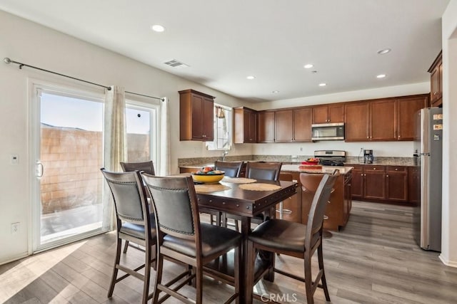 kitchen with stainless steel appliances, a kitchen island, and light wood-type flooring