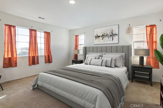 carpeted bedroom with multiple windows