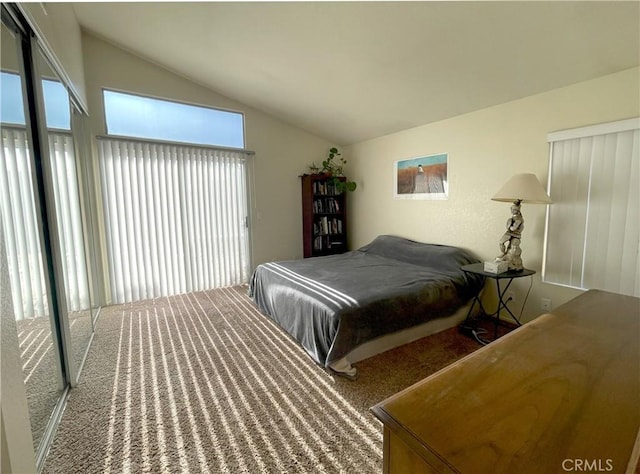 bedroom with vaulted ceiling and multiple windows