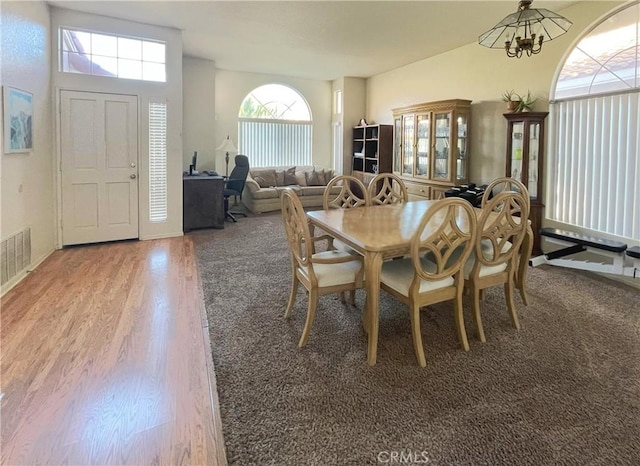 dining area featuring hardwood / wood-style flooring and a notable chandelier