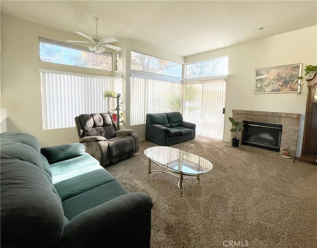 living room featuring a fireplace with flush hearth, carpet, and a ceiling fan