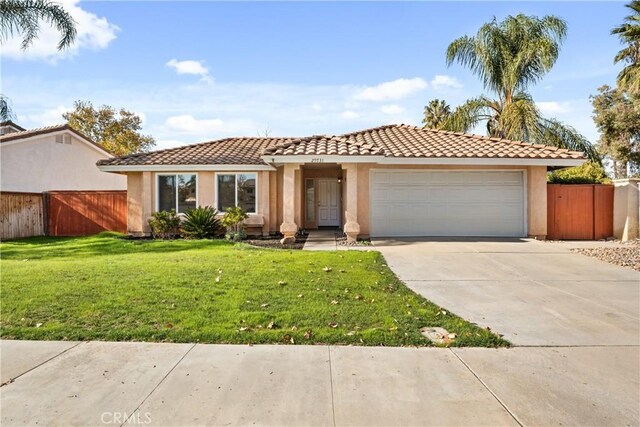 mediterranean / spanish house with a garage and a front lawn