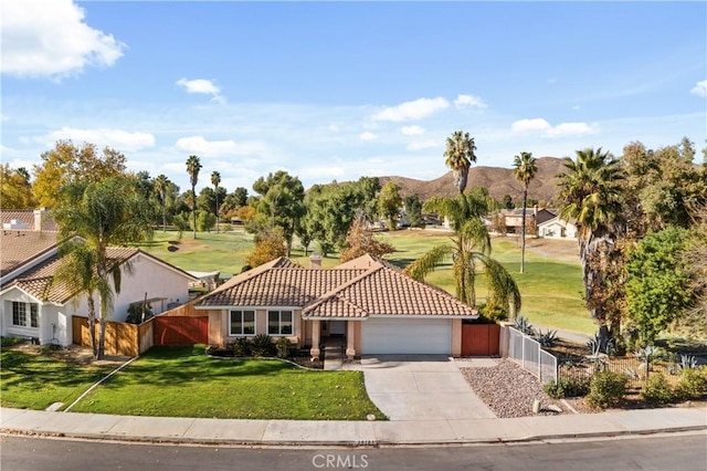 view of front of property with a mountain view, a front lawn, and a garage