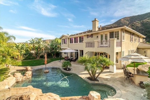 view of pool with a mountain view and a patio