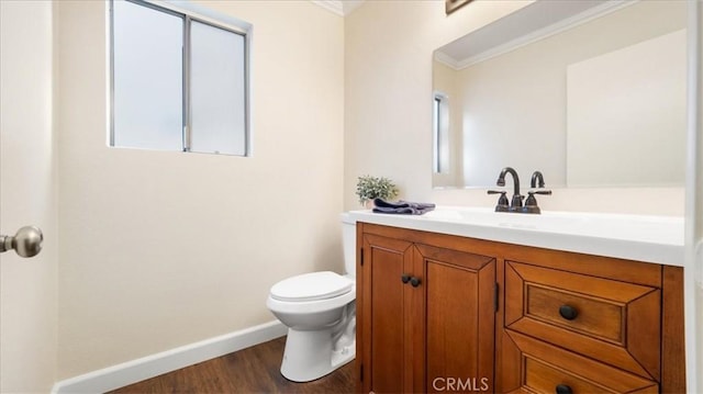 bathroom with toilet, vanity, wood-type flooring, and ornamental molding