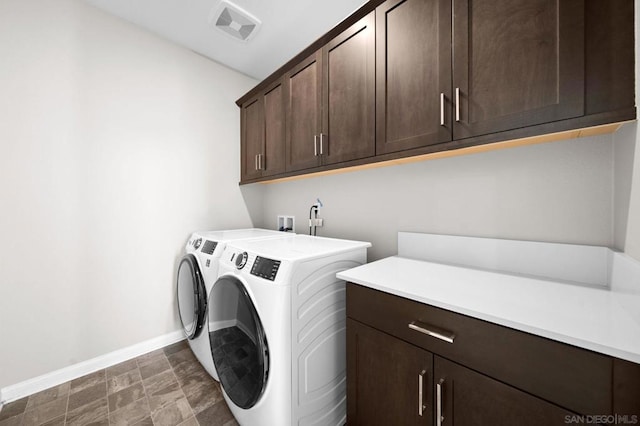 laundry room featuring cabinets and washing machine and clothes dryer