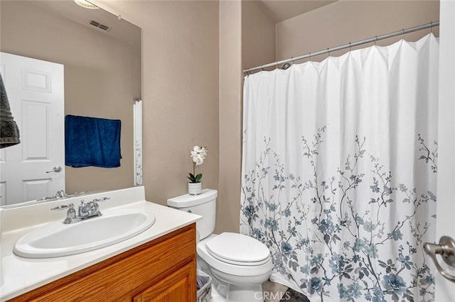 bathroom with toilet, vanity, and curtained shower