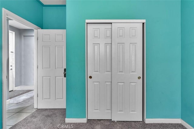 unfurnished bedroom featuring a closet and light colored carpet