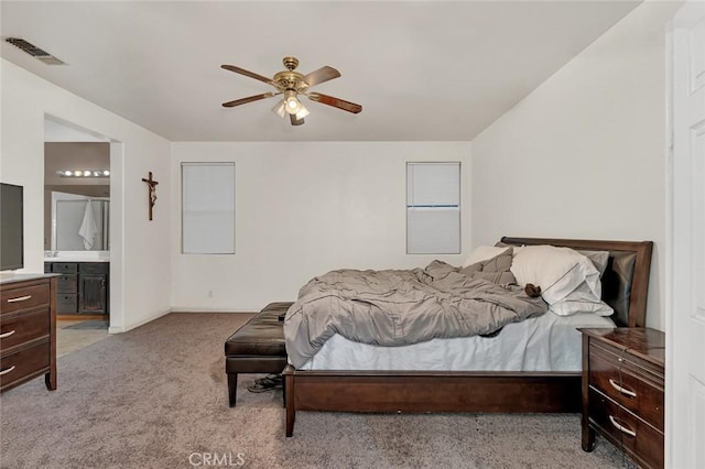 carpeted bedroom with ceiling fan and ensuite bathroom