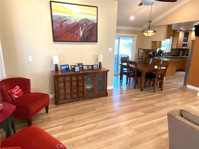 living room with ceiling fan, lofted ceiling, crown molding, and light wood-type flooring