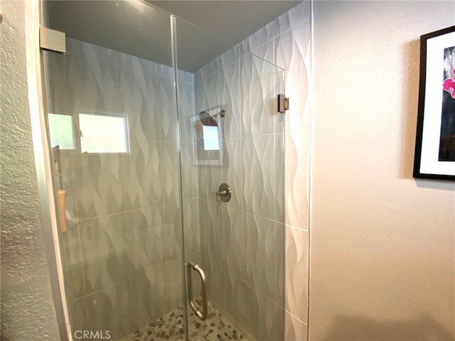 bathroom with a shower with door