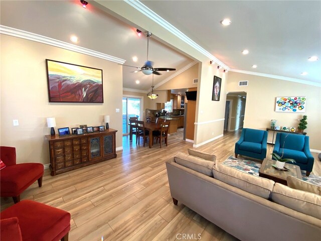 living room featuring light wood-type flooring, vaulted ceiling, ornamental molding, and ceiling fan