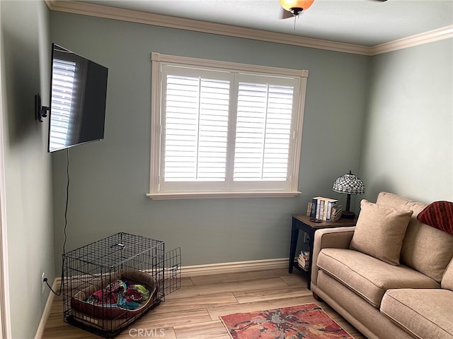 living area featuring light wood-type flooring, ceiling fan, and crown molding