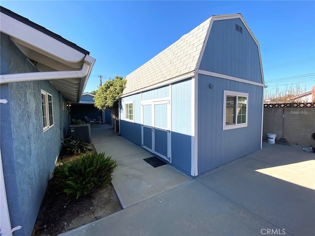 view of side of property featuring cooling unit and a patio